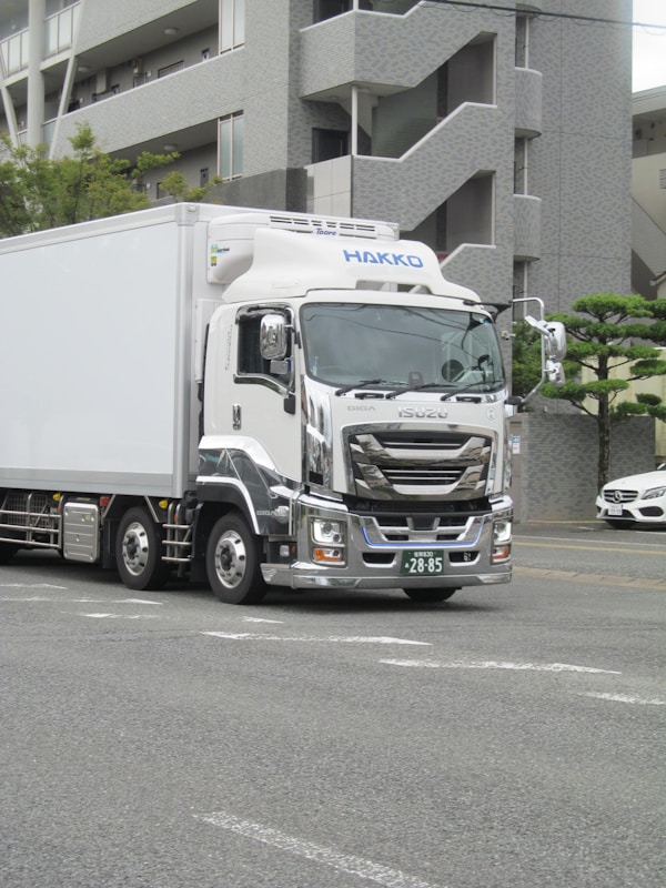 White delivery truck with chrome accents on road.